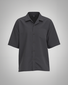 A black short-sleeve button-up shirt with a regular fit, made from 100% organically grown cotton. Designed with a structured spread collar, a single square chest pocket with precise topstitching, and a clean five-button front closure with tonal matte black buttons. The lightweight fabric has a soft matte finish, creating a refined yet relaxed silhouette.